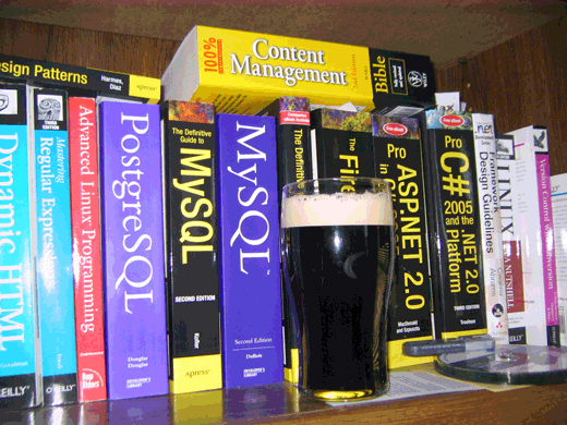 a picture of a stout beer on a shelf next to technology books